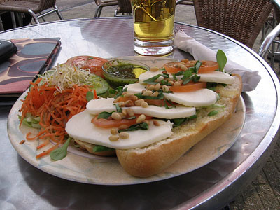bread with pesto, cheese, tomatoes and a beer